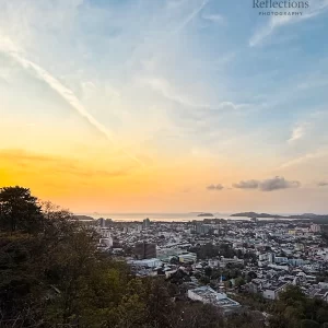 Soft sunrise sky over urban Phuket, photographed from Rang Hill Viewpoint with Patong Bay visible in the distance, used to illustrate real travel conditions for the field guide page.