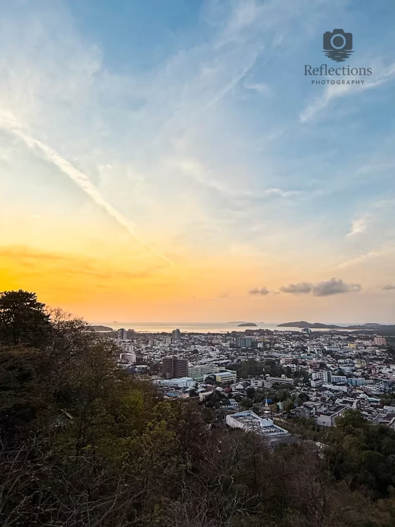 Soft sunrise sky over urban Phuket, photographed from Rang Hill Viewpoint with Patong Bay visible in the distance, used to illustrate real travel conditions for the field guide page.