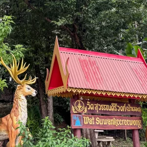 wat suwan khirri wong entrance sign with golden deer statue and red roof shelter