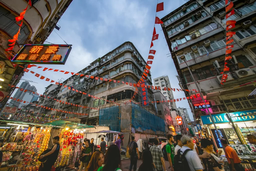 Crowded street scene with multiple signs, people, and buildings competing for attention