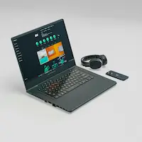 Laptop, headphones and phone on a desk – creator workspace setup