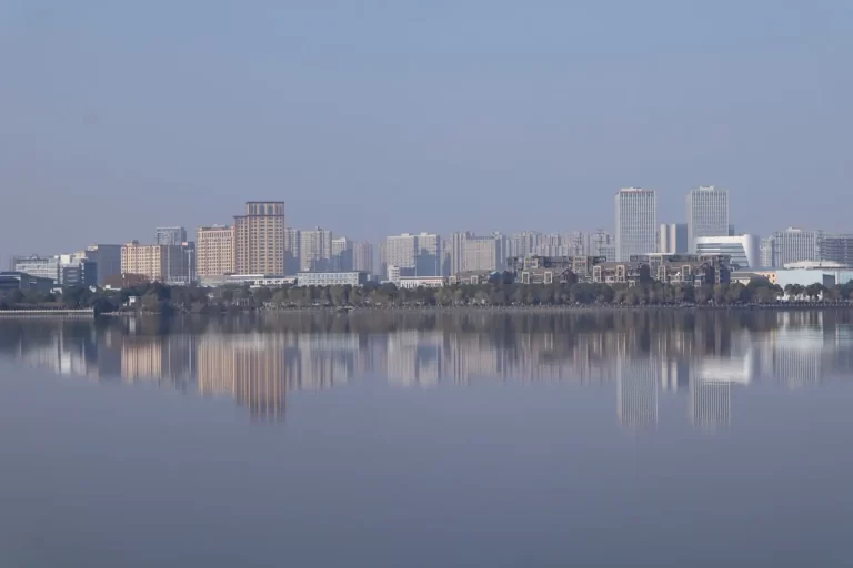 City skyline reflected in calm water creating a soft atmospheric scene. Photo used in reflections in travel photography article. Source: Pexels.