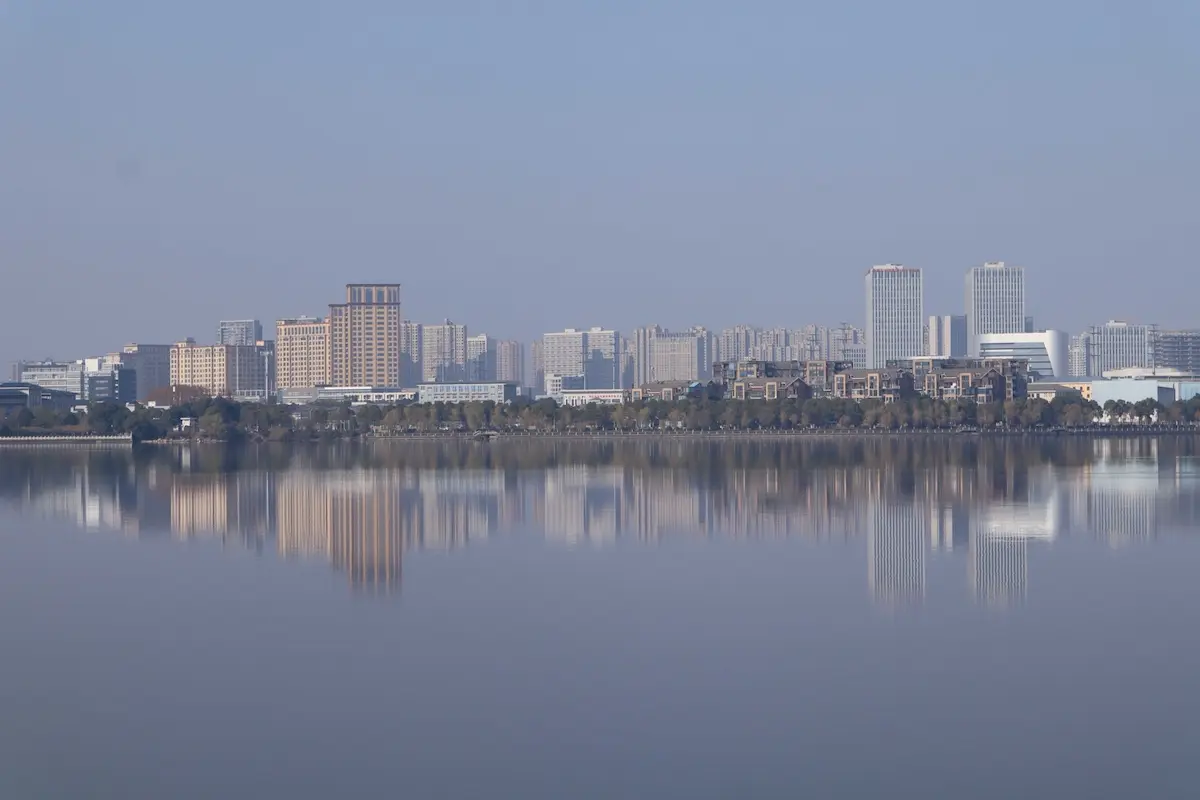 City skyline reflected in calm water creating a soft atmospheric scene. Photo used in reflections in travel photography article. Source: Pexels.